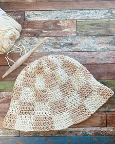 a crocheted checkerboard bucket hat sitting on top of a wooden floor