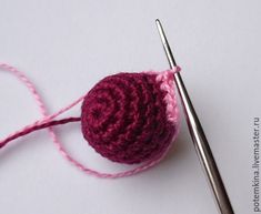 a crocheted ball of yarn next to a knitting needle