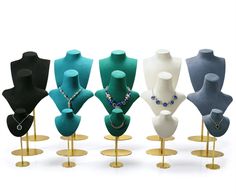 a group of mannequins with necklaces on them in different colors and sizes