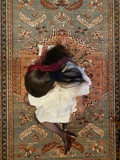 a woman laying on top of a rug