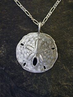 "This Atlantic Sand Dollarpendant is Sterling Silver. The included chain is a Sterling Silver Figaro 50 chain. You may choose 16, 18 or 20 inch at the same price. Other length available at sightly higher prices. This Atlantic Sand Dollar pendant measures 1\" in diameter. I hand cast all my pieces using the lost wax casting method. Please ask your needs. You may call me with questions, often I am out so please use my machine. 831-476-3176. Satisfaction Guaranteed! I send items USPS First Class un Sand Dollar Pendant, Sand Casting, Artisan Earrings, Wax Casting, Lost Wax Casting, Throat Chakra, Sand Dollar, Lost Wax, Hand Cast