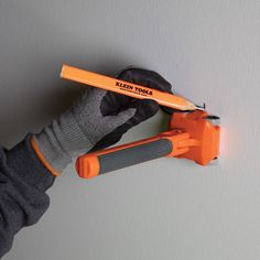 a person holding an orange and black tool