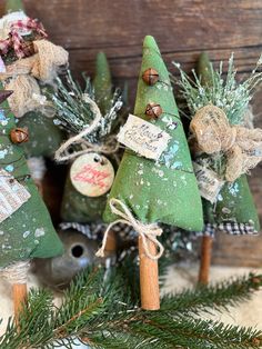 three green christmas trees with burlocks on them