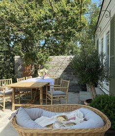 a wicker basket sitting on top of a patio next to a table and chairs