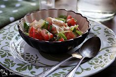 a bowl filled with vegetables sitting on top of a plate next to a glass of water