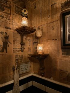 an old fashioned bathroom with newspaper wallpaper and two lamps in the corner, along with pictures on the walls