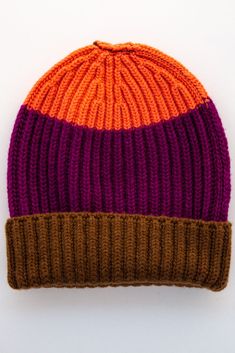 an orange and purple knitted hat on a white surface