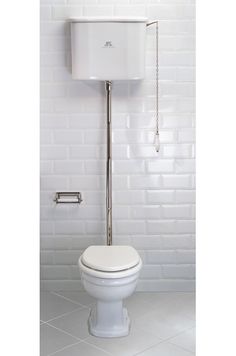 a white toilet sitting in a bathroom next to a wall mounted faucet and shower head