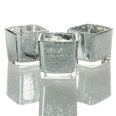 three glass candlesticks sitting on top of each other in front of a white background