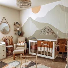 a baby's room with mountains painted on the wall, and a crib