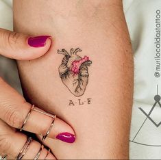 a woman's arm with a heart tattoo on it