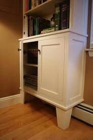 a white cabinet sitting on top of a hard wood floor