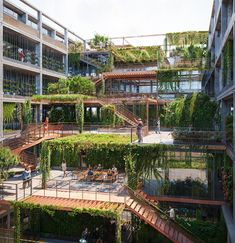 people are walking around an open courtyard with plants growing on the walls and balconies