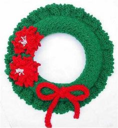 a crocheted wreath with red and green poinsettis on the front