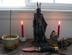 a statue and some candles on a table