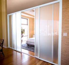 an empty room with sliding glass doors leading to a bed