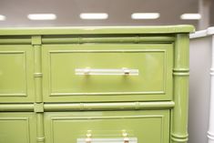 a green dresser with three drawers on each drawer