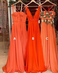 three bridesmaid dresses hanging on a rack in front of a mirror with their names