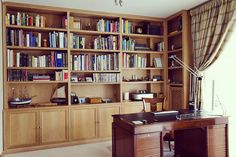 a home office with bookshelves and desk