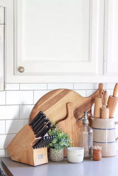 a wooden cutting board sitting on top of a kitchen counter next to a knife holder