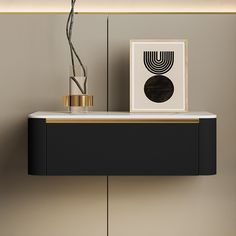 a black and gold shelf next to a vase with a plant in it on top