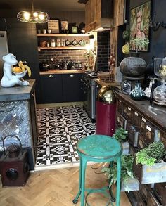 a kitchen with black and white tile flooring next to a green stool in front of an oven