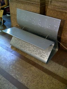 a metal bench sitting on top of a tiled floor