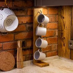 cups are hanging on the wall next to a pot rack