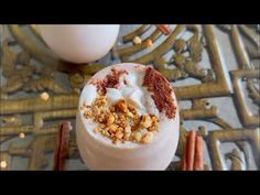 two cups filled with food sitting on top of a table next to some cinnamon sticks