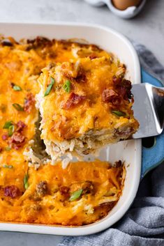 a casserole with meat and cheese is being lifted from the dish by a spatula