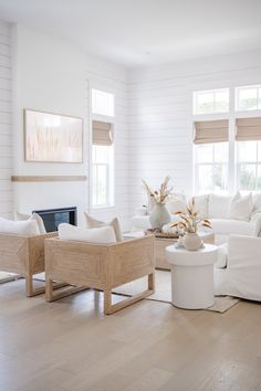 a living room with white furniture and wood floors