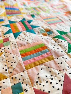 a colorful quilt with stars and stripes on it