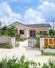 a house with a gate and flowers in the front yard