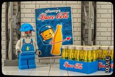 there is a lego man next to some soda bottles and a sign that says space cola