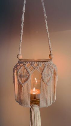 a candle is hanging from the ceiling with tassels and beads on it,