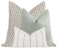 two pillows with decorative designs on them, one in grey and the other in white