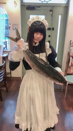 a woman dressed as a maid holding a fish