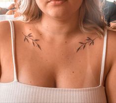 a woman with tattoos on her chest looking at the camera