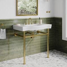 a white sink sitting under a mirror next to a wall mounted faucet in a bathroom