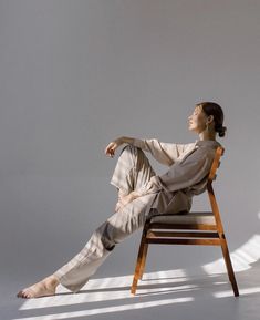 a woman sitting on top of a wooden chair