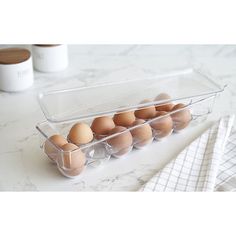 an egg tray filled with eggs on top of a white countertop next to a napkin