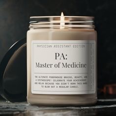 a candle that is sitting on a table next to a black container with the words pa