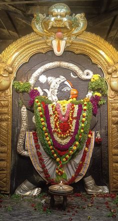 the statue is decorated with flowers and garlands