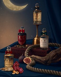 a table topped with bottles and other items next to a moon filled sky behind it