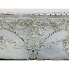 an old white painted cabinet with ornate designs