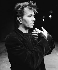 a black and white photo of a man holding his hands together