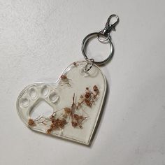 a white heart shaped keychain with brown bugs on it