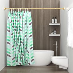 a bathroom with a tub, toilet and shower curtain that has green leaves on it