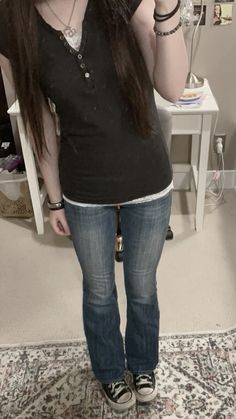 a woman with long hair is taking a selfie in front of a mirror and wearing jeans