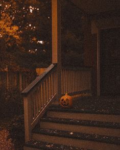 a halloween pumpkin sitting on the steps of a house